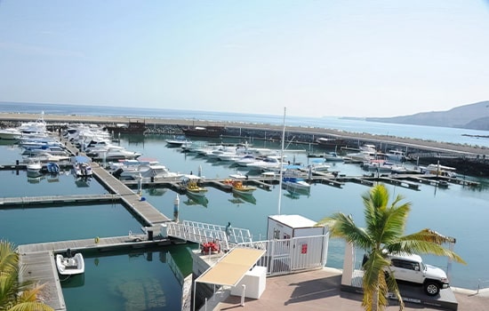 مرسى يخوت فاخر على ساحل سلطنة عمان مع قوارب راسية في الأرصفة