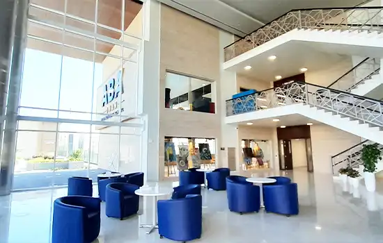 Modern and bright interior of ABA International School in Oman, with blue seating and elegant staircases