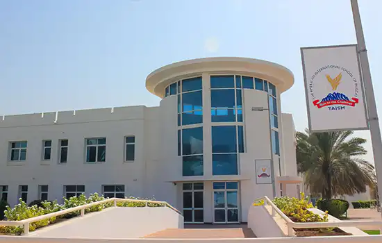 An image showing the front view of The American International School of Muscat (TAISM) building