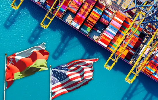 Flags of Oman and the U.S. at a shipping port, symbolizing the Free Trade Agreement (FTA) between the two nations.