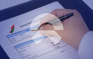 An image of a registration form being filled out by a person, with the government logo visible in the corner.