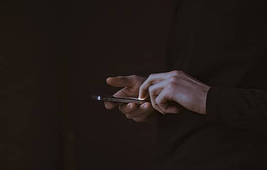فردی در حال استفاده از تلفن همراه در محیط تاریک؛ نماد استفاده نادرست از فضای مجازی